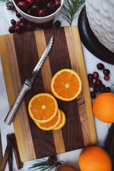 Oranges on a Cutting Board with Cranberries in the Kitchen